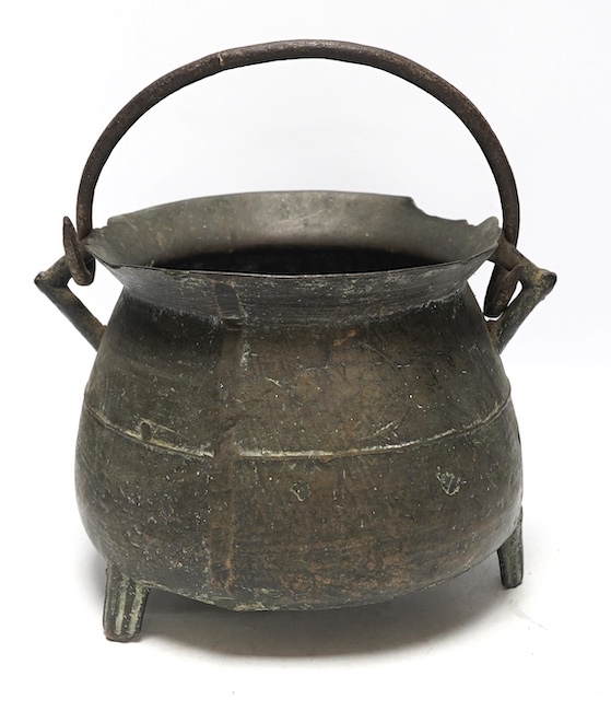 A 16th / 17th century bronze cauldron, 21.5cm tall with handle down. Condition - poor, losses and repairs to rim and body